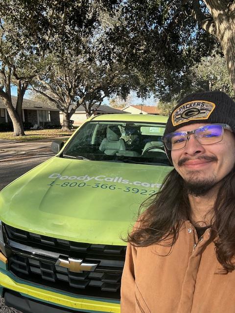 Photo of Jonas in front of a Doody Calls pick up truck